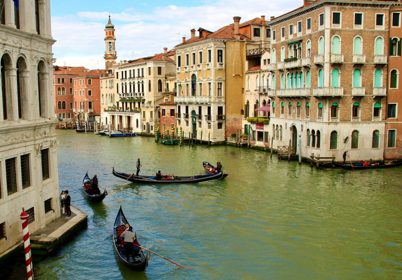 Venice's iconic gondolas glide through the Grand Canal, surrounded by historic architecture.